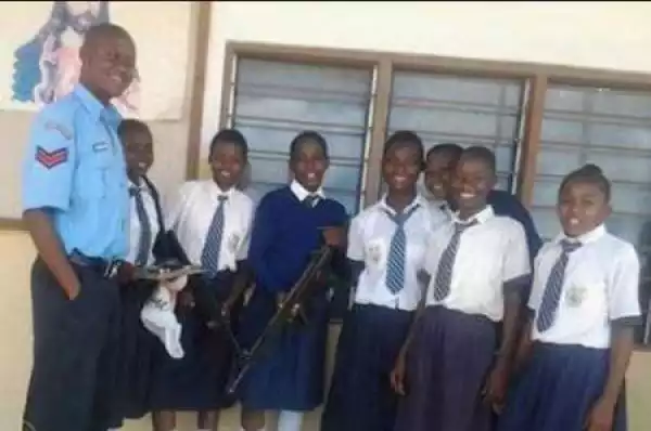 Chai! Outrage as Police Officer Allows Little Schoolgirls to Hold His Gun in Public (Photo)